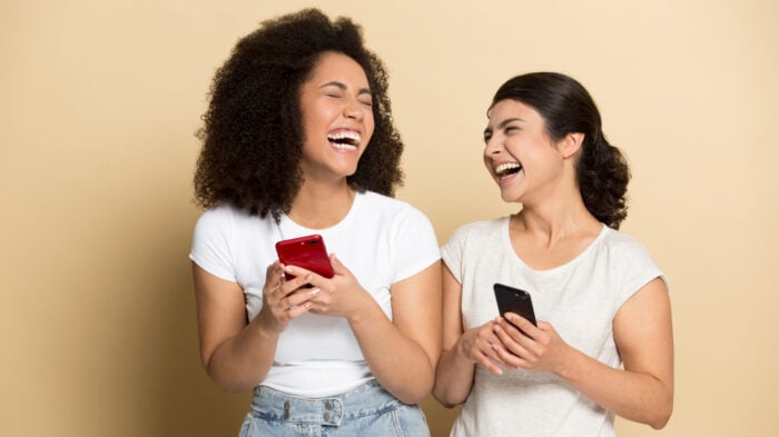 Diverse,Beautiful,Girls,Using,Phones,,Laughing,Out,Loud,At,Funny