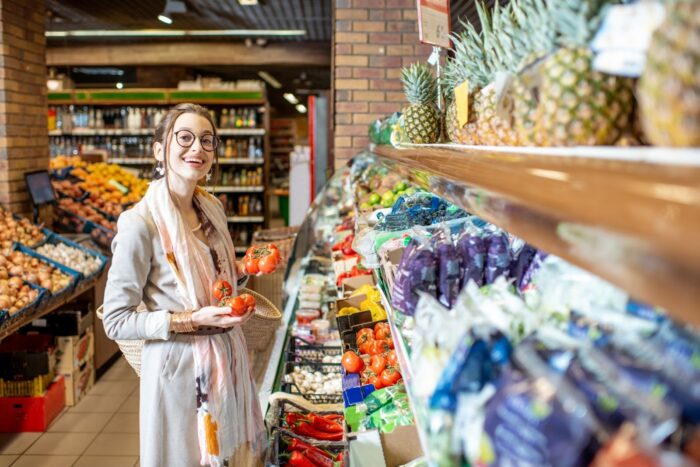 a woman choosing veggies in a health food store.