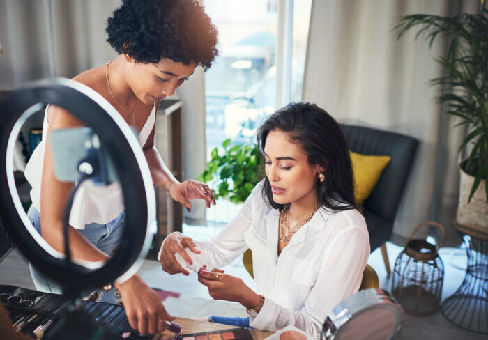 Shot of two women doing a makeup tutorial for their blog.