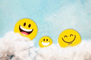 International Day of Happiness with smilling faces in the clouds